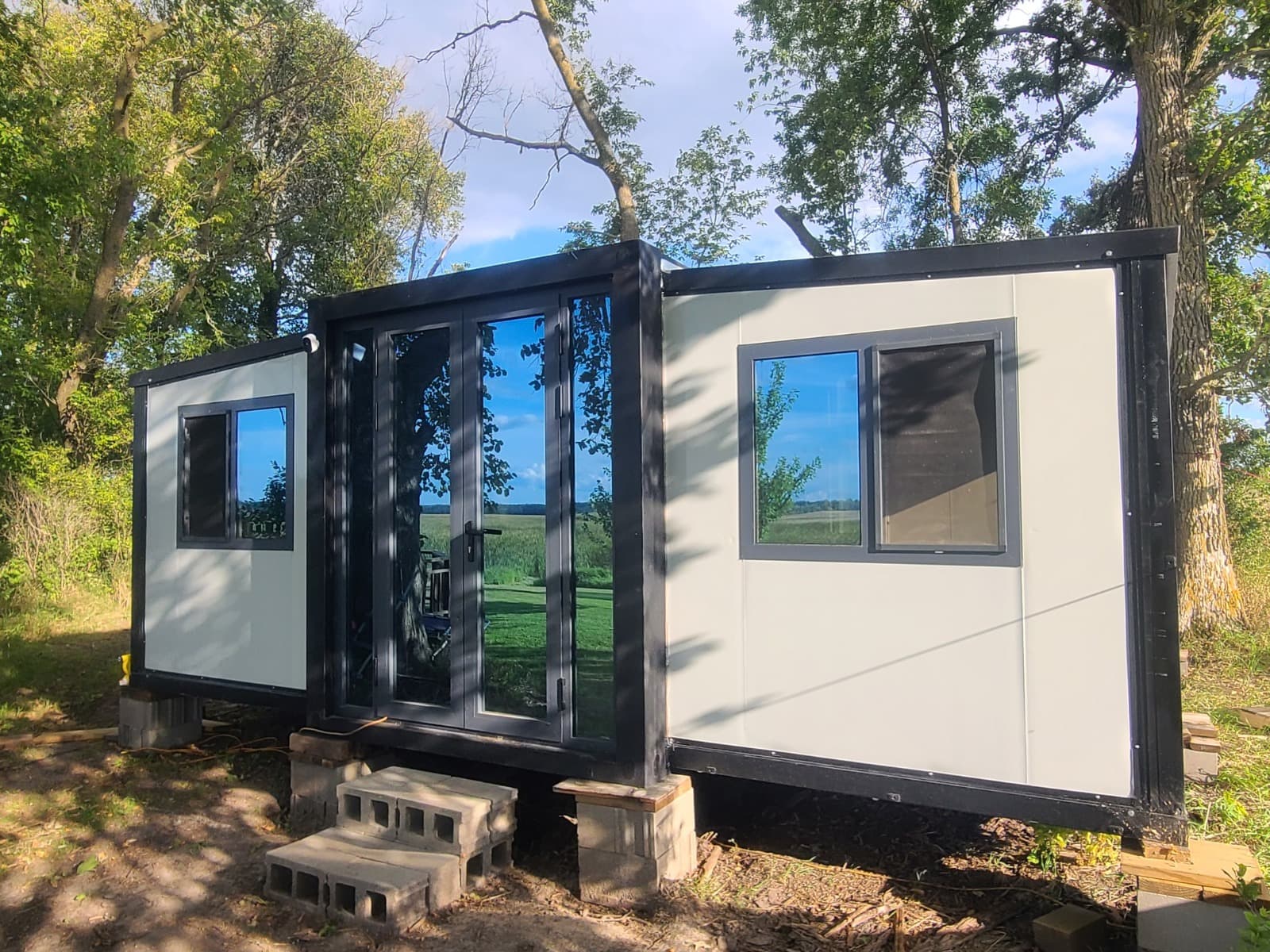 Delivered expandable home with a covered porch on a prepared pad.