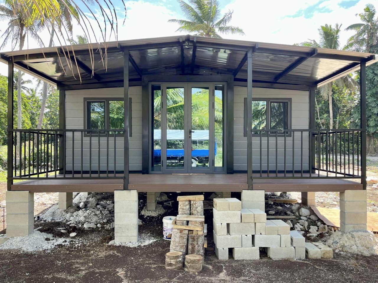 Delivered expandable home with glass entry doors on a rural lot.