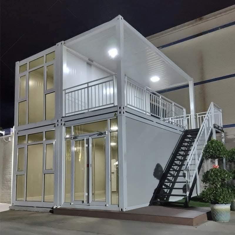 Two-story white modular assembly home with a balcony and staircase.